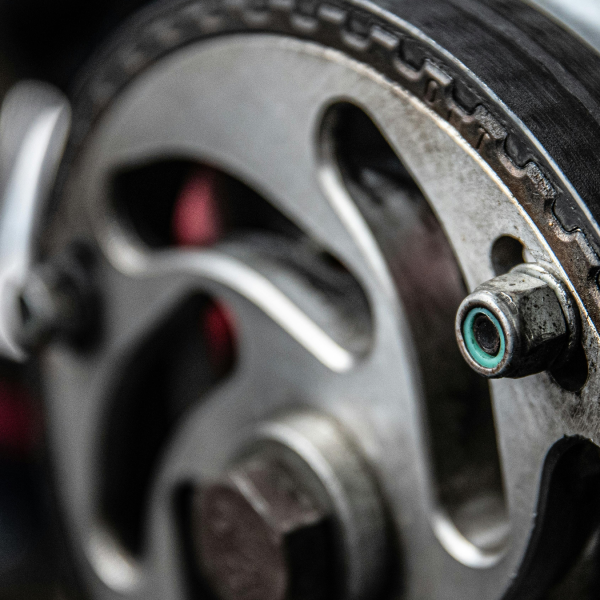 Close-up of a metallic gear and rubber belt in an engine, showcasing intricate details, textures, and industrial precision, with a focused, mechanical tone.